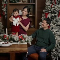 Mengenakan busana dengan tema warna Natal, merah dan hijau, Jessica dan keluarga tampil menawan. Jessica memilih dress warna burgundy dengan riasan natural dan rambut yang diikat ke belakang. Baby Julia yang digendongnya tampil dengan dress merah tua yang memiliki aksen pita warna putuh cukup besar pada bagian depannya. Foto: Instagram/@juniapics