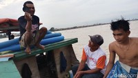 Mereka menunjukkan hasil perburuan harta karun di Sungai Musi, berupa kepingan hitam.