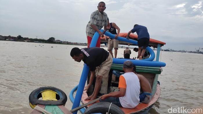 Waktu menunjukkan pukul 17.00 WIB, dan mereka yang berada di atas perahu tampak serius memegangi selang kompresor seperti sedang menyedot pasir dari dasar Sungai Musi. Itulah mereka, para pencari harta karun di Sungai Musi.