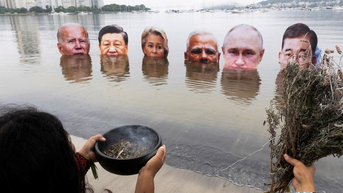 Members of the Indigenous People Association stage a protest to demand action on climate change, holding big head cut-outs of world leaders U.S. President Joe Biden, China's President Xi Jinping, European Commission President Ursula von der Leyen, India's Prime Minister Narendra Modi, Russian President Vladimir Putin and Japan's Prime Minister Shigeru Ishiba, on the waters of Botafogo Bay,  ahead of the G20 Summit, in Rio de Janeiro, Brazil November 16, 2024. REUTERS/Tuane Fernandes     TPX IMAGES OF THE DAY