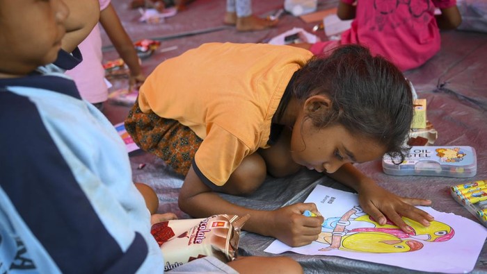 Anak-anak mengikuti kegiatan menggambar dalam layanan psikososial dari Kementerian Sosial di di Posko Pengungsi Desa Konga, Titehena, Kabupaten Flores Timur, Nusa Tenggara Timur, Sabtu (16/11/2024). Kementerian Sosial memberikan Layanan Dukungan Psikososial (LDP) kepada para pengungsi korban erupsi Gunung Lewotobi Laki-laki melalui berbagai kegiatan, seperti psikoterapi yang meliputi katarsis mental, konseling, intervensi krisis, dan pemberian motivasi hidup, serta terapi bermain untuk anak-anak, termasuk sulap dan berbagai permainan interaktif. ANTARA FOTO/Muhammad Ramdan/Spt.