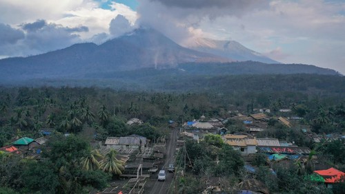 Kondisi Pasar Boru dengan latar belakang erupsi Gunung Lewotobi Laki-laki di Desa Boru, Wulanggitang, Kabupaten Flores Timur, NTT, Minggu (17/11/2024). Pasar yang merupakan pusat perdagangan terbesar dan teramai di Flores Timur bagian barat itu kini ditinggal para pedagangnya yang mengungsi ke sejumlah titik aman pascaerupsi besar Lewotobi hampir dua pekan lalu. ANTARA FOTO/Aditya Pradana Putra/rwa.