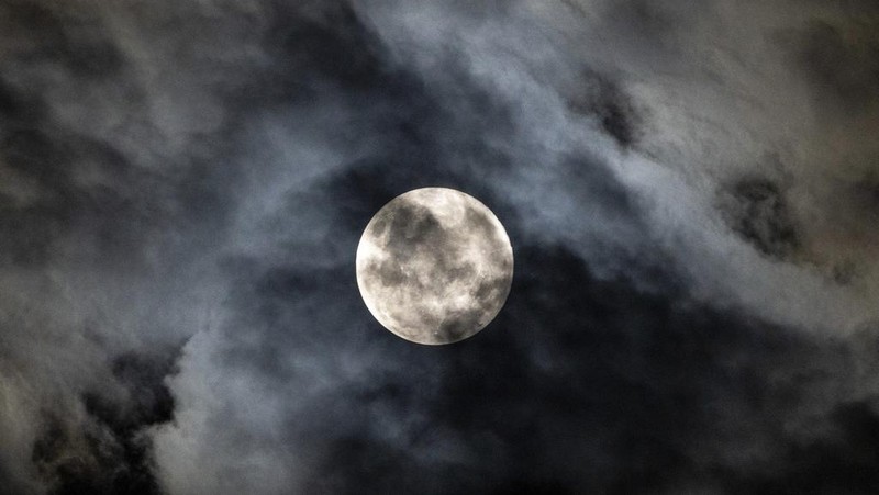 The last supermoon of 2024 breaks through the cloud cover in Johannesburg, South Africa, Friday, Oct. 15, 2024. (AP Photo/Jerome Delay)