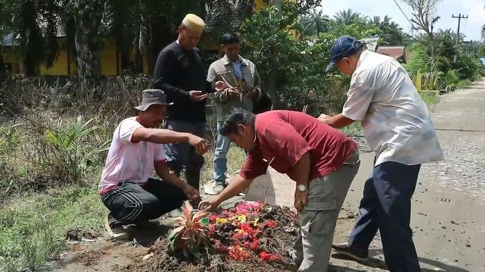 Warga Desa Gajah Sakti, Bandar Pulau, Kabupaten Asahan bangun kuburan di tepi jalan sebagai bentuk protes jalan rusak. (dok. Istimewa)