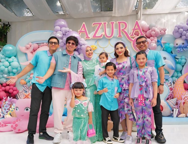 Aurel tampil mengenakan busana berwarna hijau dan ungu muda, senada dengan kedua putrinya, Ameena dan Azura. Berkonsep mermaid look, setelan busana yang dikenakan Aurel itu tampak terdiri dari atasan lengan panjang model lengan terompet dan celana panjang. Foto: Instagram/@aurelie.hermansyah