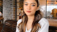 Tampil cantik dengan blouse putih, Marion Jola terlihat di sebuah restoran. Tepat di hadapannya ada sajian onion ring berukuran besar. Foto: Instagram @lalamarionjolamj