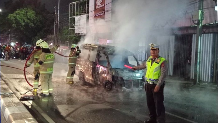 Mobil angkutan perkotaan angkot terbakar di kawasan Pasar Minggu, Jaksel. Anggota damkar sudah menangani kebakaran tersebut. (dok TMC Polda Metro Jaya)