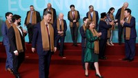 Syal yang sama juga dikenakan para pemimpin dunia lainnya. Syal itu kompak mereka kalungkan. Di belakang mereka terlihat papan besar berlatar biru dengan tulisan APEC Economic.