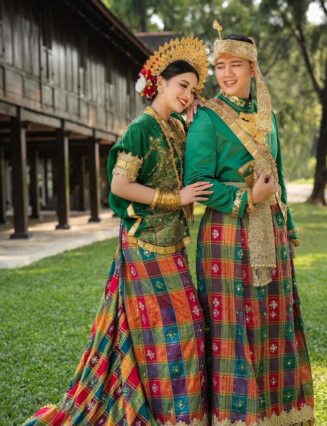 Di foto kali ini Angela dan Iptu Hafiz tampil dalam balutan busana adat Bugis. Mengengenakan atasan berwarna hijau dipadukan dengan berbagai aksesori berwarna gold dan sarung tenun khas Bugis, Angela dan Iptu Hafiz tampil memukau. Foto: Instagram/@hafizzyakbar