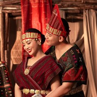 Selanjutnya ada pakaian adat khas Sumatera Utara. Mengenakan pakaian adat Batak Toba, Angela dan Hafiz melengkapi penampilan mereka dengan kain ulos. Angela tampil dengan busana bernuansa merah marun, sementara Hafiz berwarna hitam dengan aksen warna-warni. Foto: Instagram/@hafizzyakbar