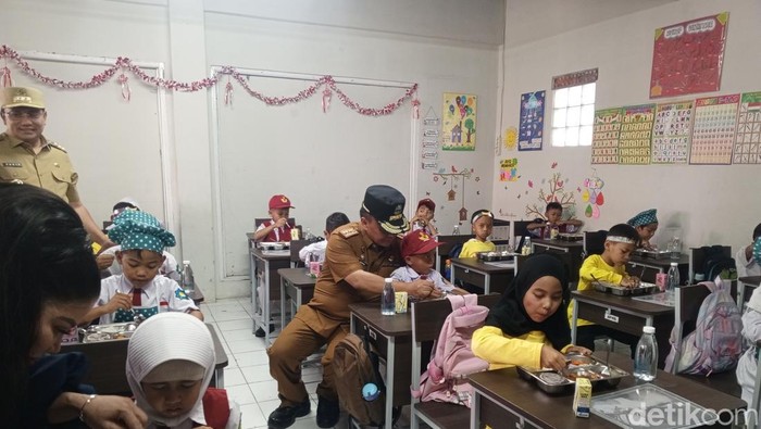 Sekda Jabar Herman Suryatman dan Pj Bupati Sumedang Yudia Ramli saat memberikan makan siang bergizi di SDN Sirahcai, Jatinangor, Senin (18/11/2024).