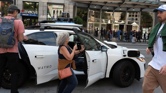 Taksi Tanpa Sopir Resmi Beroperasi di Jalanan San Francisco A customer exits a Waymo driverless taxi in San Francisco, California, U.S., September 28, 2024. REUTERS/Laure Andrillon