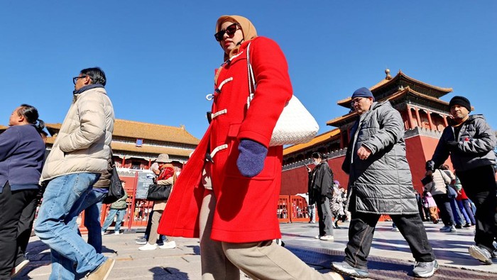 BEIJING, CHINA - NOVEMBER 17: People visiting the Palace Museum are heavily clad as temperatures drop on November 17, 2024 in Beijing, China. Beijing issued a blue alert for a cold wave on November 15 as the Beijing Meteorological Observatory expects that the night of November 17 will drop to -2 C. (Photo by Wang Xin/VCG via Getty Images)