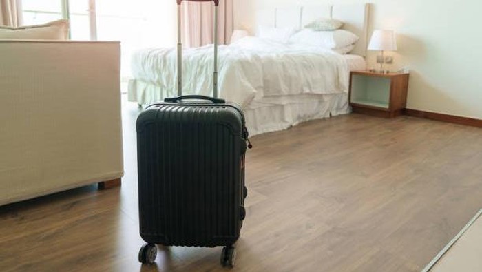 Black Luggage in modern hotel room after door opening. Baggage for Time to travel, service, journey, trip, summer holiday and vacation concepts