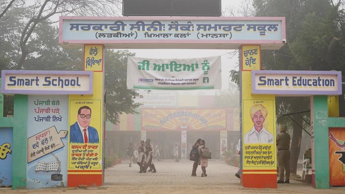 India Tutup Sekolah gegara Polusi Makin Parah Children walk at the premises of a school during a smoggy morning amid the ongoing air pollution at Mansa in the northern state of Punjab, India, November 12, 2024. REUTERS/Bhawika Chhabra