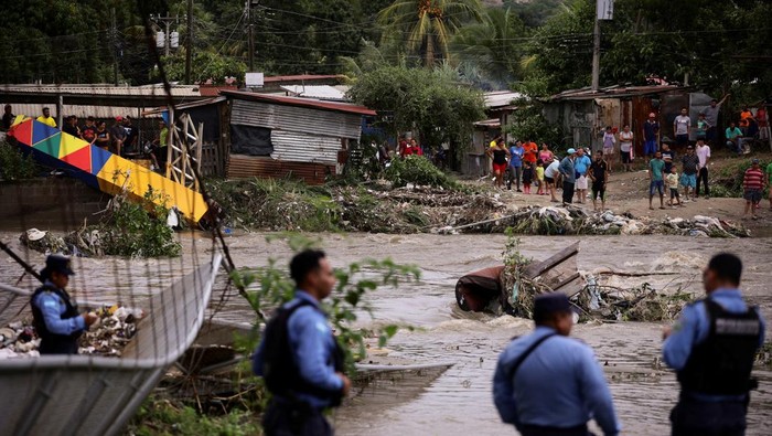 A person wades through a flooded area during an evacuation in the aftermath of tropical storm Sara, in El Progreso, Honduras, November 18, 2024. REUTERS/Yoseph Amaya REFILE - QUALITY REPEAT TPX IMAGES OF THE DAY