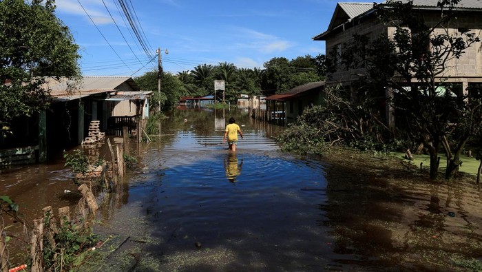 A person wades through a flooded area during an evacuation in the aftermath of tropical storm Sara, in El Progreso, Honduras, November 18, 2024. REUTERS/Yoseph Amaya REFILE - QUALITY REPEAT TPX IMAGES OF THE DAY