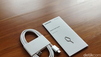 Dalam kotak kemasannya hanya ada kertas petunjuk, SIM Card injector dan kabel data. Samsung memberikan bonus adapter charger dalam penjualannya. Foto: Adi Fida Rahman/detikINET