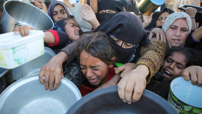 Palestinians gather to receive food cooked by a charity kitchen, amid a hunger crisis, as the Israel-Gaza conflict continues, in Khan Younis in the southern Gaza Strip, November 19, 2024. REUTERS/Hatem Khaled