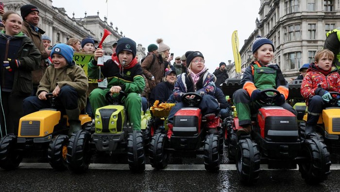 Children sit in toy tractors, as farmers protest against the Labour government's new agricultural policy, which includes a budget measure expected to increase inheritance tax liabilities for some farmers, in London, Britain, November 19, 2024. REUTERS/Mina Kim     TPX IMAGES OF THE DAY