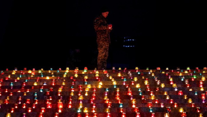 A military cadet lights a candle during a commemorative ceremony on the 1000th day of Russia's full scale attack on Ukraine, in front of the 'Motherland' monument in Kyiv, Ukraine November 19, 2024.  REUTERS/Valentyn Ogirenko     TPX IMAGES OF THE DAY