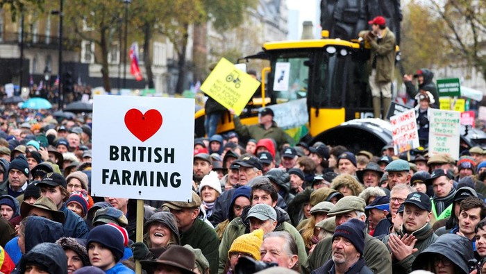Members of the farming community drive tractors past a police van during a demonstration protesting against the Labour government's new agricultural policy, which includes a budget measure expected to increase inheritance tax liabilities for some farmers, in London, Britain, November 19, 2024. REUTERS/Toby Melville