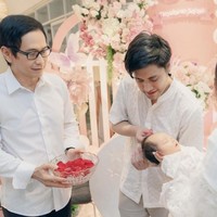 Kevin dan Vicy kompak menjalani satu per satu rangkaian acara. Dalam foto terlihat Kevin yang sedang menggunting rambut sang anak, sementara Vicy yang menggendong baby Kimova. Foto: Instagram/@vicymelanie