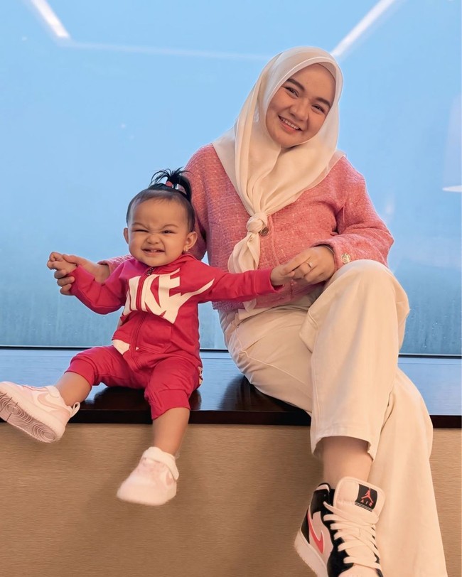 Istri Witan Sulaiman, Rismahani tak ketinggalan turut hadir menonton langsung pertandingan Timnas Indonesia melawan Arab Saudi. Tak hadir sendiri, Rismahani mengajak serta putri kecil mereka. Ibu dan anak itu tampil kompak dalam balutan busana berwarna merah muda. Foto: Instagram