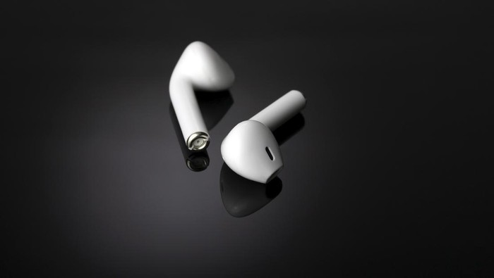 White wireless headphones close-up on a dark background.