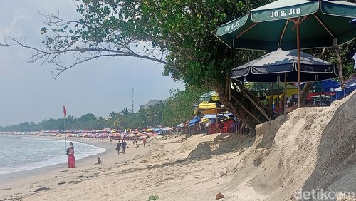 Kondisi ombak pantai Kuta hampir menerjang turis yang sedang duduk santai di bibir pantai, Rabu (20/11/2024). 
(Agus Eka/detikBali)