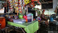 Meski warung-warung mereka terendam banjir, para pedagang tetaop membuka dagangan mereka.  