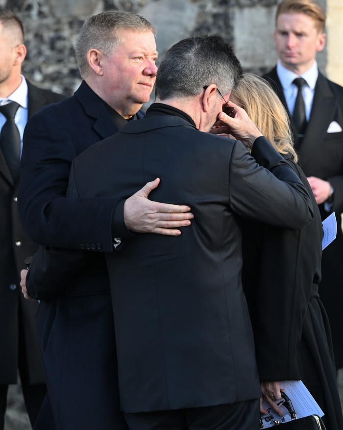AMERSHAM, ENGLAND - NOVEMBER 20: Simon Cowell is comforted by Geoff Payne (L) as they depart the funeral for singer Liam Payne, former member of One Direction, on November 20, 2024 in Amersham, England. Former One Direction star Liam Payne's private funeral in Amersham has been widely anticipated to draw celebrities and fans alike, wishing to pay their final respects. The singer died after falling from a hotel balcony in Buenos Aires on October 16. (Photo by Karwai Tang/WireImage)