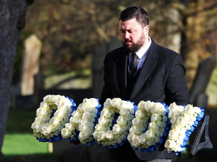 A man carries a themed floral tribute for former One Direction singer Liam Payne outside St. Marys Church on the day of the signers funeral, in Amersham, near London, Britain, November 20, 2024. REUTERS/Toby Melville