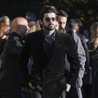 Zayn Malik tampak mengenakan jas hitam beludru dipadu kemeja motif. Penyanyi 31 tahun ini menampakkan raut wajah yang sangat berduka di balik kacamata hitamnya. Foto: AP/Andrew Matthews