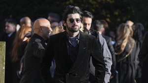 Tak lama kemudian, Louis Tomlinson menyusul, diikuti Zayn Malik dan Niall Horan, semuanya berpakaian serba hitam, mencerminkan suasana duka yang mendalam. (AP Photo/Andrew Matthews)