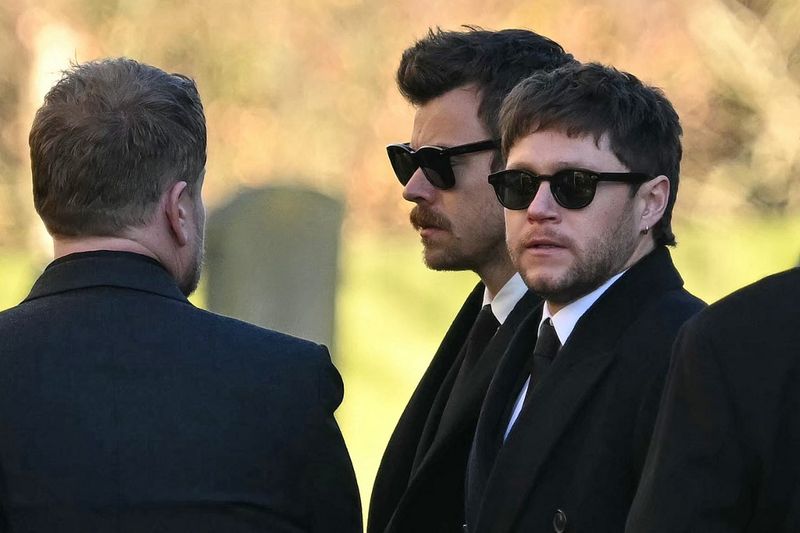 Former One Direction band members Harry Styles (C) and Niall Horan leave after attending the funeral service of the late One Direction singer Liam Payne, at a St Mary's church in Amersham, west of London on November 20, 2024. The funeral of former One Direction singer Liam Payne who died last month after falling from his Buenos Aires hotel room was held on Wednesday. (Photo by JUSTIN TALLIS / AFP)