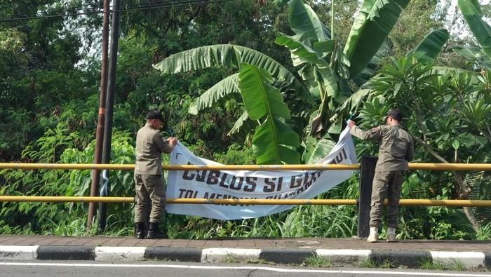 Petugas mencopot sejumlah spanduk di Tabanan, Kamis (21/11/2024). (Dok. KPU Tabanan)