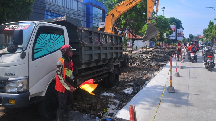 Potret Perbaikan Jalan di Kudus dengan Dana Cukai Tembakau Pekerja menggunakan alat berat melakukan pengerukan Jalan Jendral Ahmad Yani yang mengalami kerusakan di Kudus, Jawa Tengah, Kamis (21/11/2024). Dinas Pekerjaan Umum dan Penataan Ruang (PUPR) Kabupaten Kudus melakukan perbaikan jalan kabupaten sepanjang 497 meter tersebut menggunakan anggaran dari Dana Bagi Hasil Cukai Hasil Tembakau (DBHCHT) Pemkab Kudus tahun anggaran 2024 sebesar Rp4,6 miliar. ANTARA FOTO/Yusuf Nugroho/nz