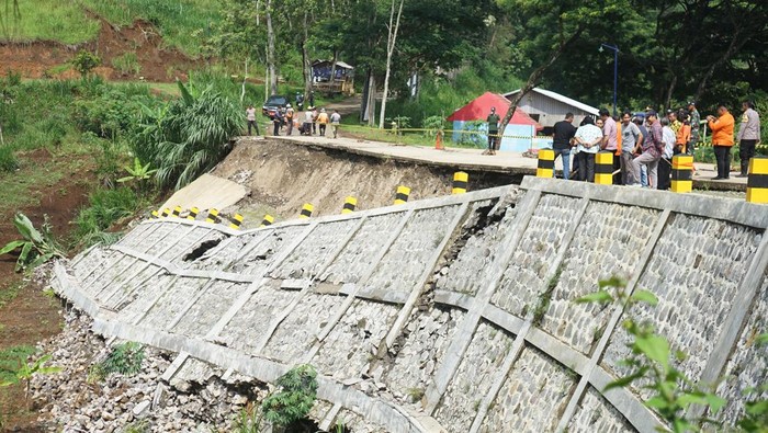Talud Jalan di Tulungagung Amblas Gegara Hujan Deras Petugas memeriksa kondisi bahu jalan yang amblas terseret longsor di jalur Selingkar Wilis, Desa Samar, Kecamatan Pagerwojo, Tulungagung, Jawa Timur, Kamis (21/11/2024). Konstruksi plengseng/talud sepanjang 50 meter dengan ketinggian sekitar 11 meter tersebut ambruk akibat hujan deras yang mengguyur wilayah itu pada Rabu (20/11) sehingga menyebabkan separuh badan jalan amblas dan arus lalu lintas diberlakukan sistem buka-tutup. ANTARA FOTO/Destyan Sujarwoko/nym.