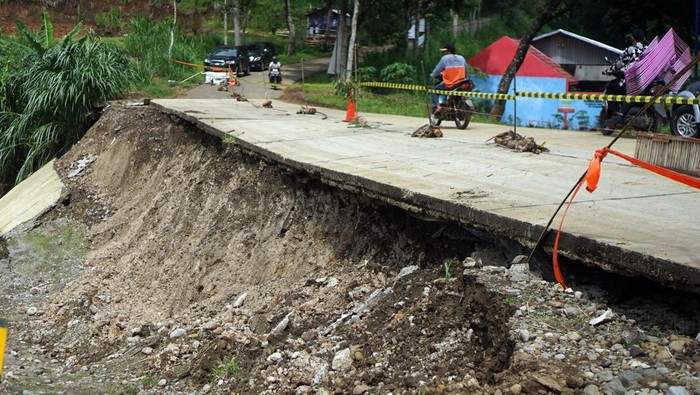 Talud Jalan di Tulungagung Amblas Gegara Hujan Deras Petugas memeriksa kondisi bahu jalan yang amblas terseret longsor di jalur Selingkar Wilis, Desa Samar, Kecamatan Pagerwojo, Tulungagung, Jawa Timur, Kamis (21/11/2024). Konstruksi plengseng/talud sepanjang 50 meter dengan ketinggian sekitar 11 meter tersebut ambruk akibat hujan deras yang mengguyur wilayah itu pada Rabu (20/11) sehingga menyebabkan separuh badan jalan amblas dan arus lalu lintas diberlakukan sistem buka-tutup. ANTARA FOTO/Destyan Sujarwoko/nym.