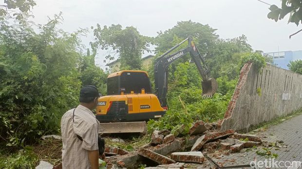 Ekskavator mini dikerahkan untuk merobohkan tembok miring yang sebagian menimpa mobil siang tadi di Pedurungan Kidul, Kota Semarang, Kamis (21/11/2024).