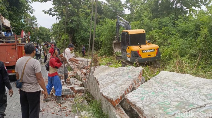 Ekskavator mini dikerahkan untuk merobohkan tembok miring yang sebagian menimpa mobil siang tadi di Pedurungan Kidul, Kota Semarang, Kamis (21/11/2024).