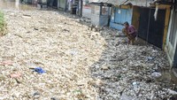 Warga membersihkan tumpukan sampah yang terbawa banjir di Dayeuhkolot, Kabupaten Bandung, Jawa Barat, Jumat (22/11/2024). 