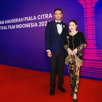 Prilly Latuconsina anggun berkebaya beluru hitam dengan aksen bordir yang mewah. Kebaya berkerap scallop dipadankan kain batik warna cokelat tua. Pulasan lipstik merah terang memberi aura glamor pada penampilannya. Foto: Instagram