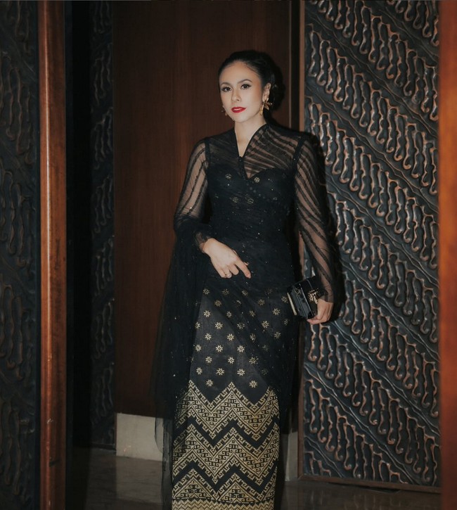 Kebaya hitam transparan menonjolkan sisi anggun, tradisional sekaligus modern pada penampilan Wulan Guritno. Kebaya kontemporer itu dipadukan dengan songket hitam berhias bordir emas. Busana merupakan koleksi dari Tangan Prive. Foto: Instagram