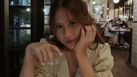 Santai di bistro, begini gaya Nadin menunggu makanan tiba. Ia memegang segelas air putih di tangannya. Foto: Instagram cakecaine