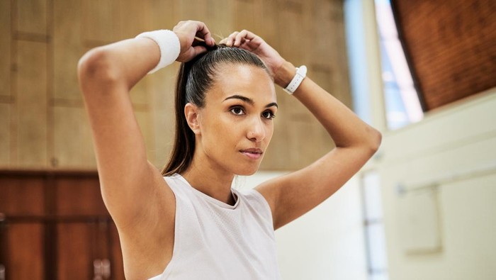Ilustrasi wanita sedang menguncir rambut.