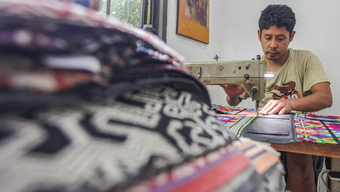 Pekerja menyelesaikan pembuatan tas tenun kain khas Sumba di salah satu industri rumahan di Pamulang, Tangerang Selatan, Jumat (22/11/2024). Tas berbahan tenun asal Nusa Tenggara Timur tersebut dipasarkan seharga Rp1 juta-Rp3 juta per unit ke sejumlah daerah di Indonesia, Malaysia, dan Singapura sekaligus untuk mempromosikan kain tenun sebagai khazanah budaya Indonesia. ANTARA FOTO/Zaky Fahreziansyah/app/YU