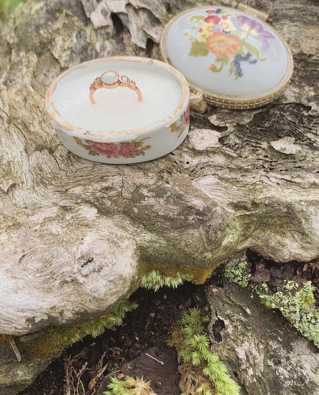 Cincin yang diberikan tampak berwarna emas dengan batu berwarna putih yang menghiasi bagian tengahnya. Di salah satu unggahannya terlihat cincin tersebut diletakkan di sebuah tempat porselen unik bergambar bunga. Foto: Instagram/@cakecaine