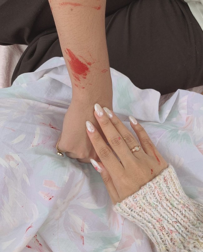 “Just two kids, the happiest whenever together,” tulis keterangan unggahan. Dalam foto terlihat tangan Nadin dan Faishal yang sama-sama terkena pewarna saat melukis. Faishal sendiri diketahui merupakan adik Sheila Dara sekaligus adik ipar Vidi Aldiano. Foto: Instagram/@cakecaine